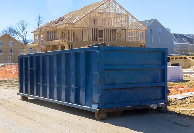 a residential dumpster with wooden planks sticking out of it